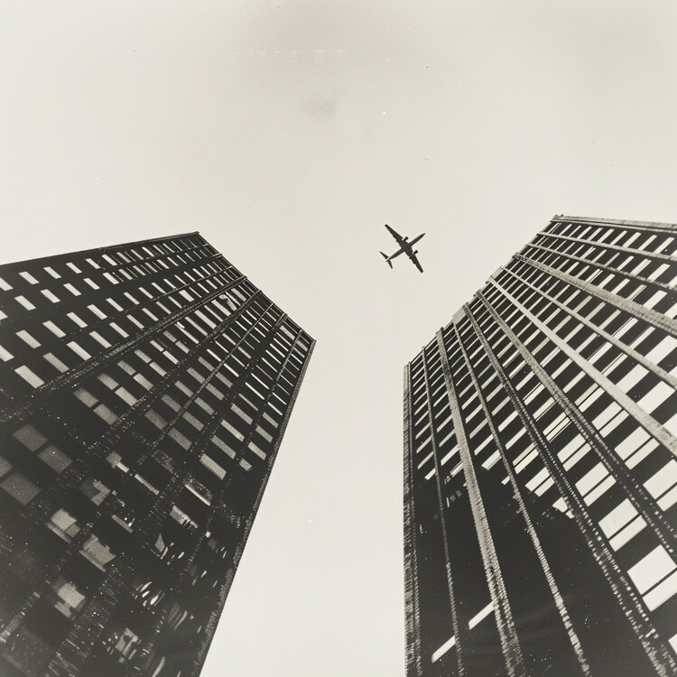 Plakat Plane flying across two towers , photography with & black