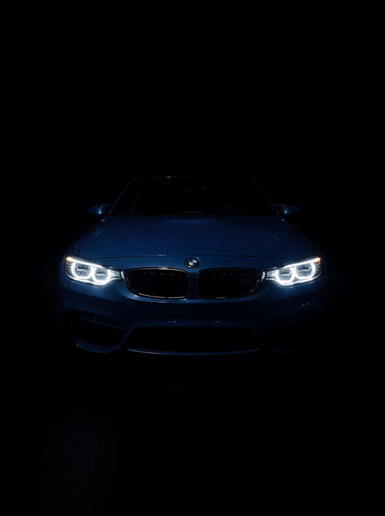 Poster A Sleek Blue BMW Emerging from the Shadows
